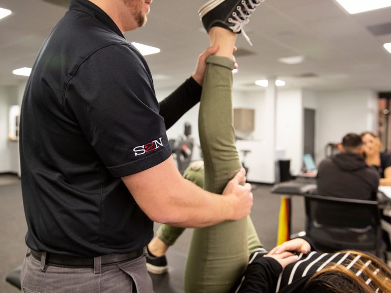 A physical therapist helps alleviate leg pain.