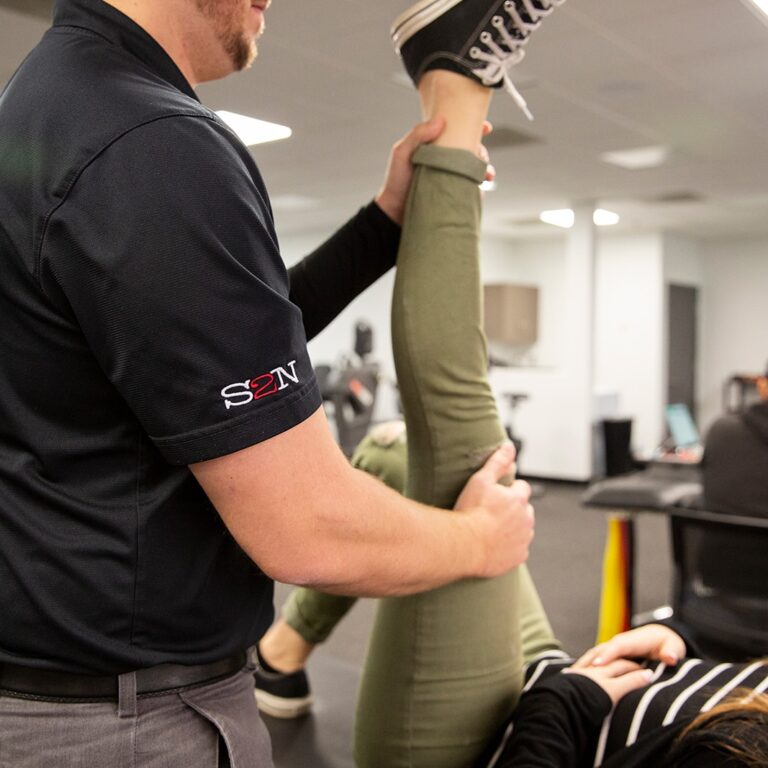 A physical therapist helps alleviate leg pain.
