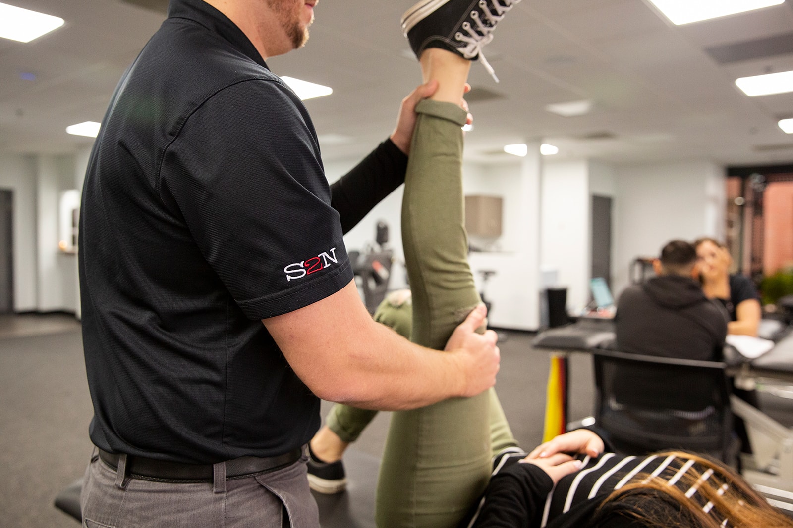 A physical therapist helps alleviate leg pain.