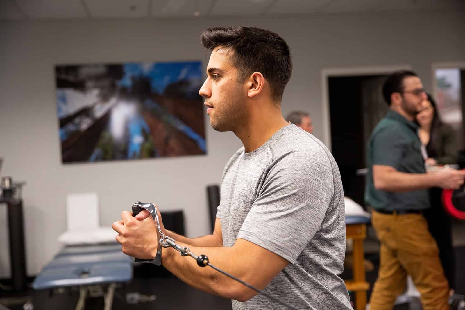 Man performing resistance band exercise in a fitness class at PRO~PT.