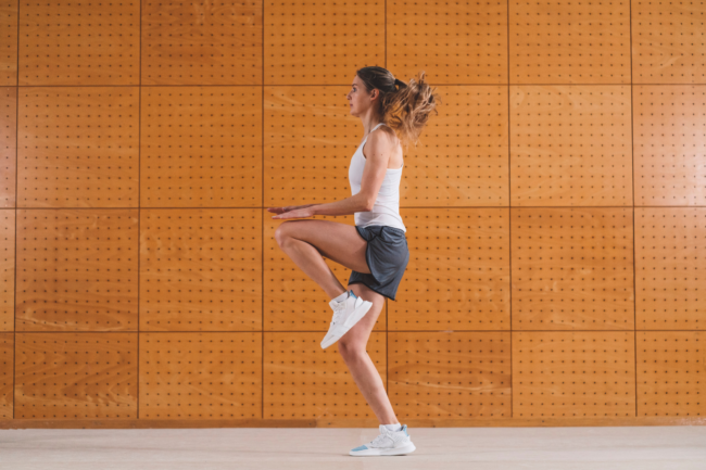 Woman performing a knee raise exercise to help relieve patellar tendonitis
