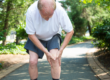 Man clutches his knee while on a run