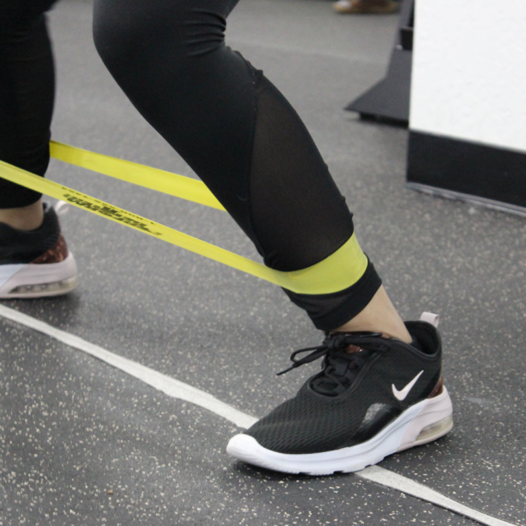 A woman performs exercises directed by a physical therapist