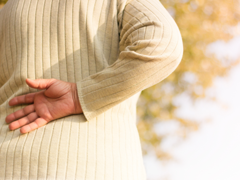 Woman holds her back to to lower back pain