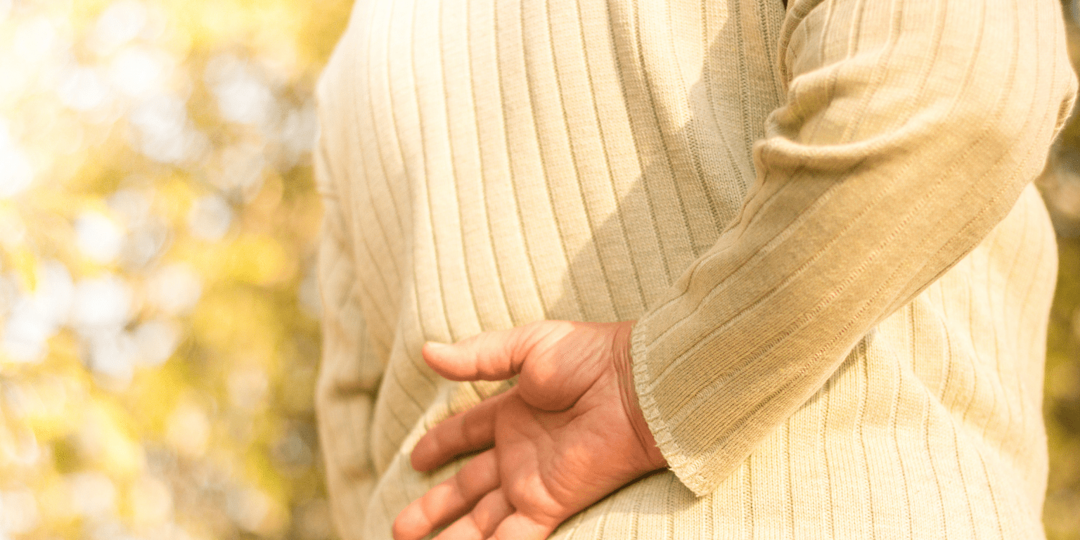 Woman holds her lower back due to pain