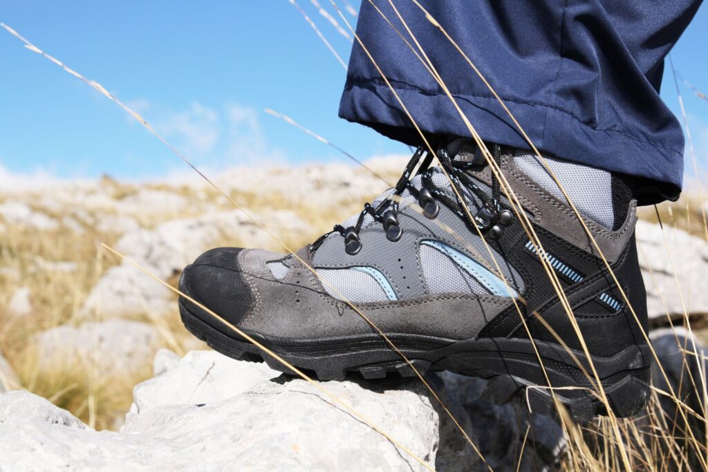 Closeup of a hikers shoe standing on top of rocky terrain