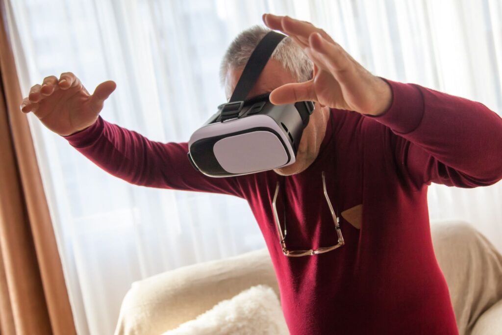Senior man having fun playing with a VR headset