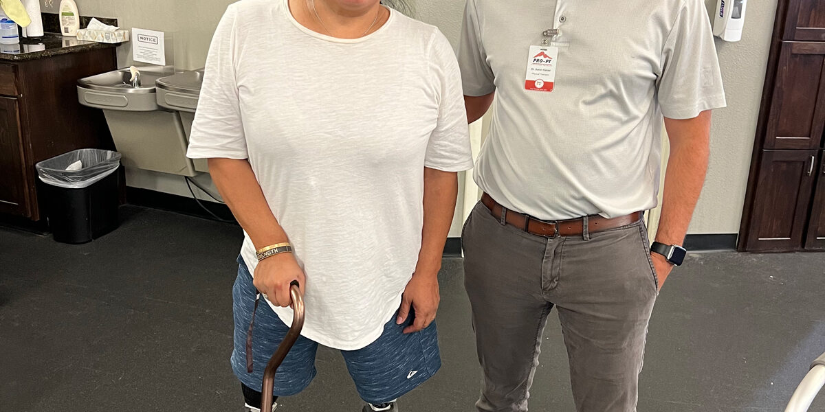 Andrea smiling and standing next to a PRO PT physical therapist