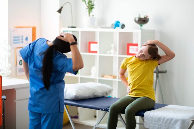 Therapist performing head and neck exercises with patient.