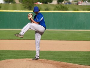 A baseball pitcher winding up for a pitch.