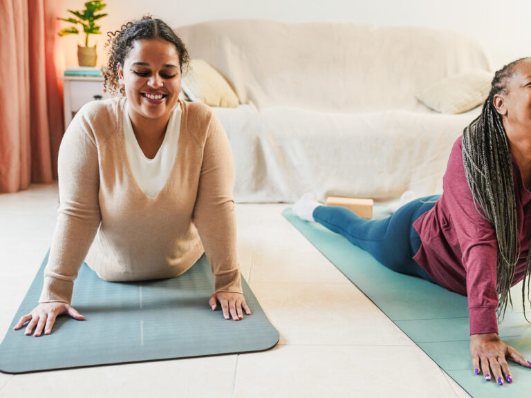 Mother and daughter doing yoga day routine at home together Family and sport concept during winter time Focus on girl face