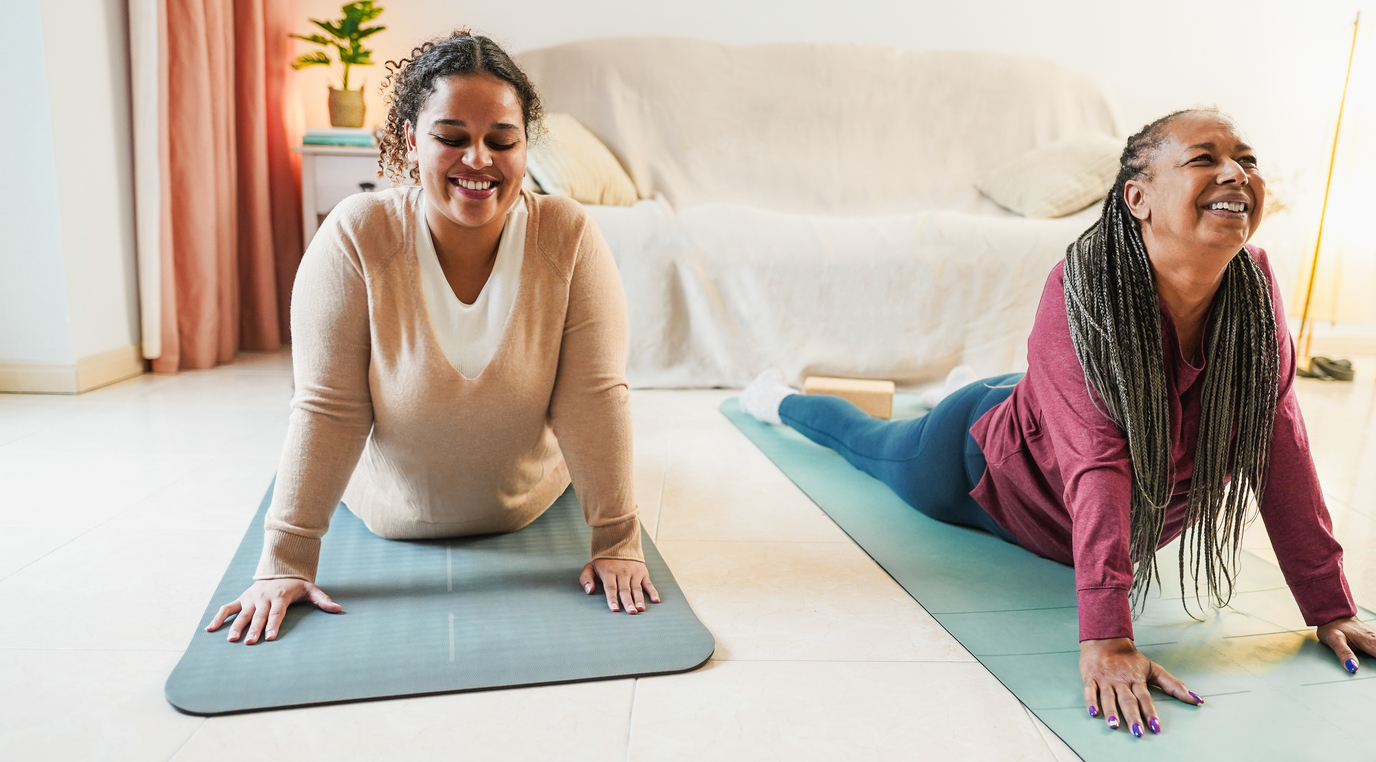 Mother and daughter doing yoga day routine at home together Family and sport concept during winter time Focus on girl face